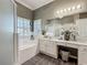 Bright bathroom featuring large double vanity, soaking tub, and walk-in shower at 24436 Madewood Ave, Leesburg, FL 34748