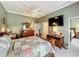 A spacious bedroom with a large TV, ceiling fan and traditional-style furnishings, desk and chair at 24436 Madewood Ave, Leesburg, FL 34748