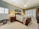 Spacious primary bedroom with neutral carpet, shuttered windows, and ensuite bath at 24436 Madewood Ave, Leesburg, FL 34748