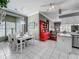 Open-concept dining area featuring a white table, tile floor, and access to kitchen and living area at 24436 Madewood Ave, Leesburg, FL 34748