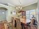 Elegant dining room featuring a large wooden table, upholstered chairs, and ample natural light at 24436 Madewood Ave, Leesburg, FL 34748