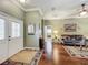 Inviting foyer with hardwood floors, elegant decor, and a view into the living room at 24436 Madewood Ave, Leesburg, FL 34748