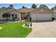 Inviting home with a well-maintained lawn, brick driveway, and an array of potted plants enhancing curb appeal at 24436 Madewood Ave, Leesburg, FL 34748