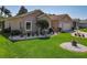 Beautifully landscaped front yard with vibrant green grass, decorative stones, and a variety of potted plants at 24436 Madewood Ave, Leesburg, FL 34748