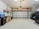 A large, clean garage with a golf cart, storage shelves, and organization system at 24436 Madewood Ave, Leesburg, FL 34748