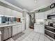 Bright kitchen featuring white cabinetry, stainless steel appliances, and tile flooring at 24436 Madewood Ave, Leesburg, FL 34748