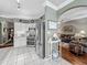 Kitchen featuring stainless steel appliances, white cabinets, tile floor, and view into the living room at 24436 Madewood Ave, Leesburg, FL 34748