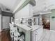 Kitchen with island, bar seating, white cabinets, and view into the living area at 24436 Madewood Ave, Leesburg, FL 34748