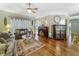 Comfortable living room with hardwood floors, a ceiling fan, and a bright window at 24436 Madewood Ave, Leesburg, FL 34748