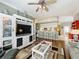 Open living space with hardwood floors, a sofa, entertainment center, and open access to the kitchen at 24436 Madewood Ave, Leesburg, FL 34748