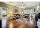 Comfortable living room with hardwood floors, a ceiling fan, and a bright window at 24436 Madewood Ave, Leesburg, FL 34748