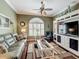 Well-lit living room with hardwood floors, a comfortable sofa, and entertainment center at 24436 Madewood Ave, Leesburg, FL 34748
