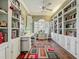 Home office with custom built-in shelves, hardwood floors, and a large desk area at 24436 Madewood Ave, Leesburg, FL 34748