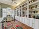 Bright office featuring custom built-in bookshelves with ladder and hardwood flooring at 24436 Madewood Ave, Leesburg, FL 34748