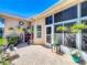 A cozy patio space features brick pavers, potted plants, and a screened-in lanai for outdoor enjoyment at 24436 Madewood Ave, Leesburg, FL 34748