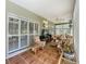 A cozy sunroom featuring wicker furniture, tile flooring, and large windows overlooking a well-manicured yard at 24436 Madewood Ave, Leesburg, FL 34748