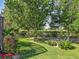 Lush backyard with mature trees and manicured landscaping at 25523 Maurepas Ln, Leesburg, FL 34748