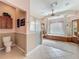 Bright bathroom with a soaking tub, a shower, decorative columns, and tile flooring at 25523 Maurepas Ln, Leesburg, FL 34748