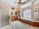 Bright bathroom with double sinks, soaking tub, stand up shower, and tile flooring at 25523 Maurepas Ln, Leesburg, FL 34748
