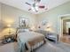 Comfortable bedroom with neutral walls, soft carpet flooring, window, ceiling fan, and stylish furnishings at 25523 Maurepas Ln, Leesburg, FL 34748