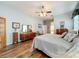 Comfortable bedroom features wood flooring, a ceiling fan, and neutral décor at 25523 Maurepas Ln, Leesburg, FL 34748