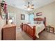 Bedroom with a plush bed, carpet, and warm wooden furniture accents at 25523 Maurepas Ln, Leesburg, FL 34748