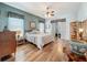 Bedroom with wood flooring, ceiling fan, and a sliding door to the back patio at 25523 Maurepas Ln, Leesburg, FL 34748