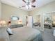 Bedroom with large closets, soft carpet flooring, neutral walls, ceiling fan, and neutral colored bedding at 25523 Maurepas Ln, Leesburg, FL 34748