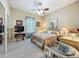 Comfortable bedroom features a ceiling fan, carpet, and television at 25523 Maurepas Ln, Leesburg, FL 34748