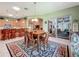 Bright dining room with kitchen, living room, and screened room views and lots of natural light at 25523 Maurepas Ln, Leesburg, FL 34748