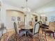 Chandelier-lit dining room featuring a mirrored wall, and round table at 25523 Maurepas Ln, Leesburg, FL 34748