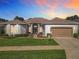 Charming single-story home featuring a well-manicured lawn and a two-car garage at 25523 Maurepas Ln, Leesburg, FL 34748