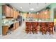 Bright kitchen with many cabinets, countertops, stainless appliances, and a breakfast bar at 25523 Maurepas Ln, Leesburg, FL 34748
