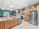 Spacious kitchen with stainless steel appliances, tile floors, and ample counter space at 25523 Maurepas Ln, Leesburg, FL 34748