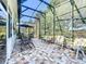 Screened in lanai with a tiled floor and outdoor seating area at 25523 Maurepas Ln, Leesburg, FL 34748