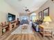 Spacious living room featuring hardwood floors, ceiling fan, and a comfortable leather sofa at 25523 Maurepas Ln, Leesburg, FL 34748
