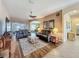 Open-concept living room with comfortable seating, wood-look floors, ceiling fan, and abundant natural light at 25523 Maurepas Ln, Leesburg, FL 34748