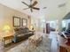 Cozy living room featuring comfortable leather seating, wood-look floors, ceiling fan and neutral wall colors at 25523 Maurepas Ln, Leesburg, FL 34748