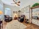 Comfortable living room with hardwood floors, leather chairs, and a ceiling fan at 25523 Maurepas Ln, Leesburg, FL 34748