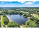 Picturesque aerial view of the community lake surrounded by mature trees and well-maintained landscaping at 26736 Cash Ct, Leesburg, FL 34748