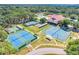 Aerial view showcasing tennis courts, and community amenities surrounded by lush landscaping at 26736 Cash Ct, Leesburg, FL 34748
