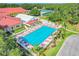 Aerial view of the community pool with ample seating and nearby clubhouse surrounded by greenery at 26736 Cash Ct, Leesburg, FL 34748