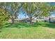 Expansive backyard featuring lush green grass and mature trees, ideal for outdoor activities and relaxation at 26736 Cash Ct, Leesburg, FL 34748