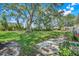 Expansive backyard with mature trees, a lush lawn, and a patio, perfect for outdoor living at 26736 Cash Ct, Leesburg, FL 34748