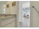 Bright bathroom with single sink and storage, leading to a charming laundry room for added convenience at 26736 Cash Ct, Leesburg, FL 34748