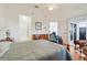 Spacious bedroom featuring light wood floors, a ceiling fan, and access to both bathroom and sunroom at 26736 Cash Ct, Leesburg, FL 34748