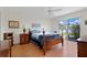 Cozy bedroom featuring a classic wood bed frame, ceiling fan, and sliding glass door to the patio at 26736 Cash Ct, Leesburg, FL 34748