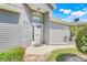 Inviting home entrance with light-gray siding, a charming front door, and transom window detail at 26736 Cash Ct, Leesburg, FL 34748