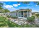 A rear exterior view of the home showing the back patio, screened in porch and landscaped yard at 26736 Cash Ct, Leesburg, FL 34748
