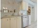 View of kitchen with stainless steel dishwasher, ample counter space and white cabinets for lots of storage at 26736 Cash Ct, Leesburg, FL 34748